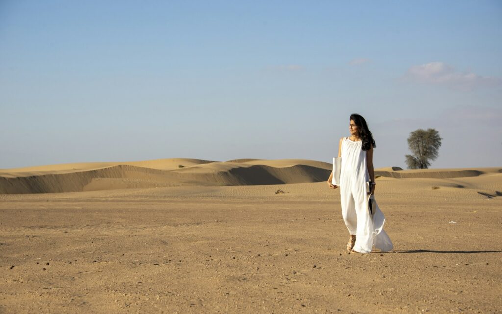 Traveler walking through golden desert dunes